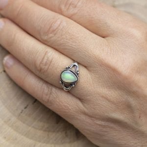 Silver ring with opal gemstone caboshon on female hand